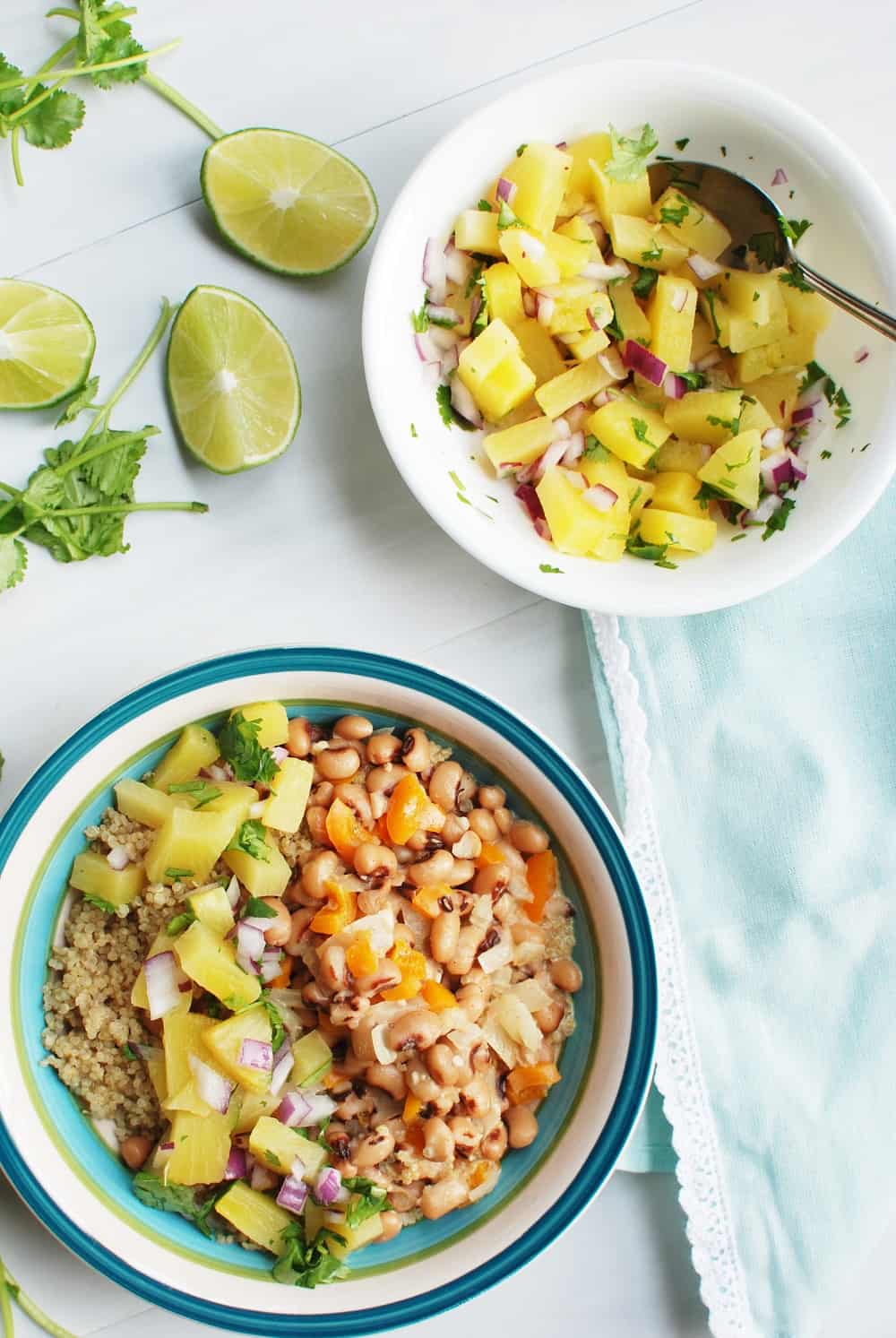 Vegan black eyed peas and quinoa next to a bowl of pineapple salsa