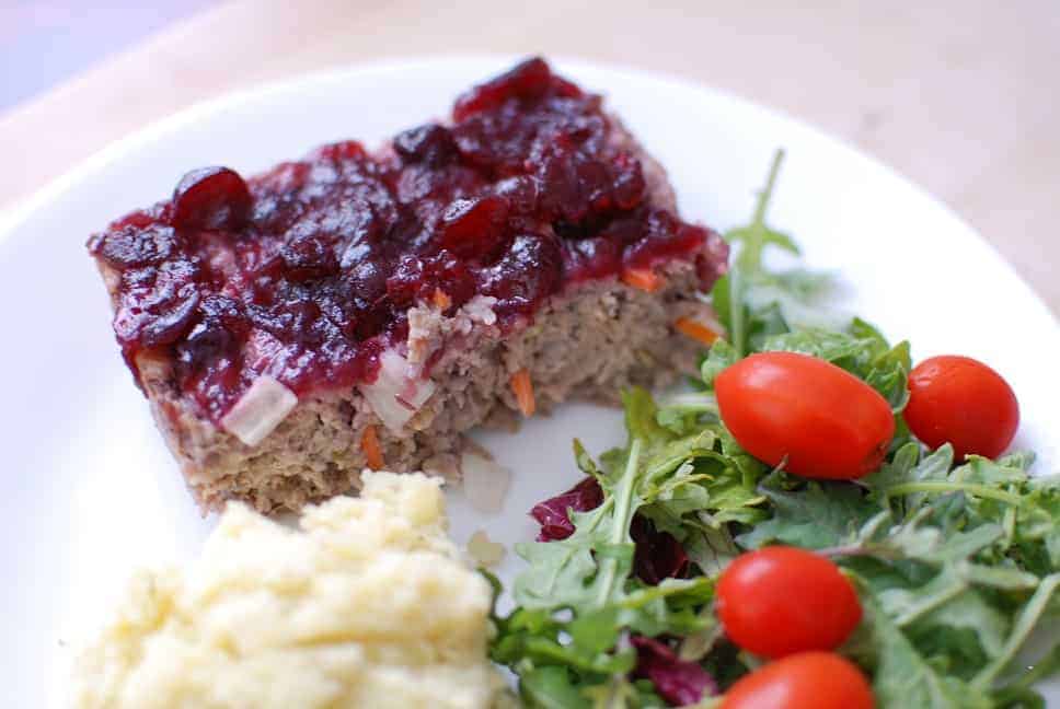 Cranberry chicken meatloaf on a plate next to mashed potatoes