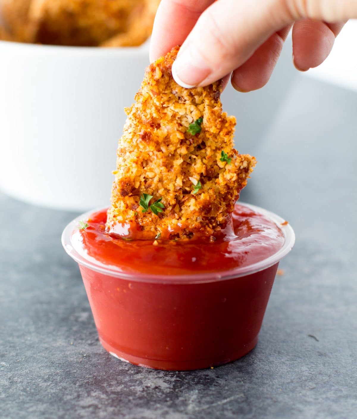 Gluten free chicken tenders dipped in ketchup