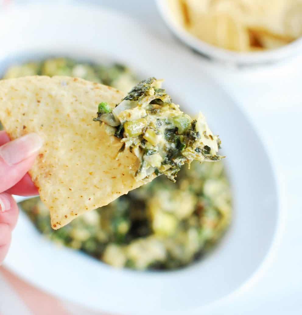 A tortilla chip loaded with dairy free spinach artichoke dip