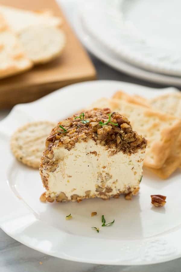 Dairy Free Cheeseball appetizer next to crackers on a white plate