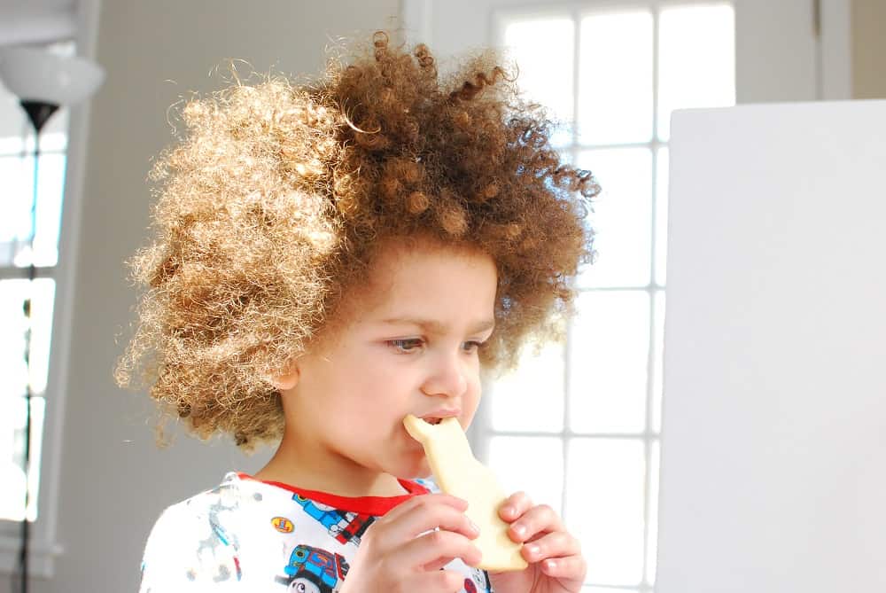 A child eating a dairy free sugar cookie