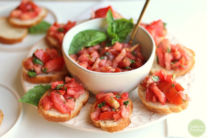 Dairy Free Bruschetta Appetizer on a plate with a bowl of tomatoes in the middle