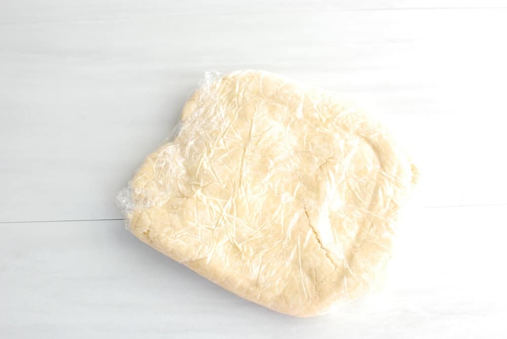 dairy free pie crust rolled into a disc and wrapped in plastic wrap