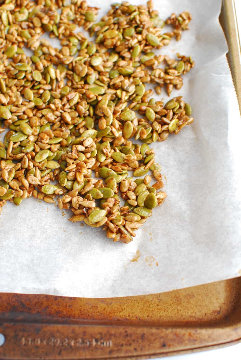 maple glazed pumpkin and sunflower seeds on a baking sheet