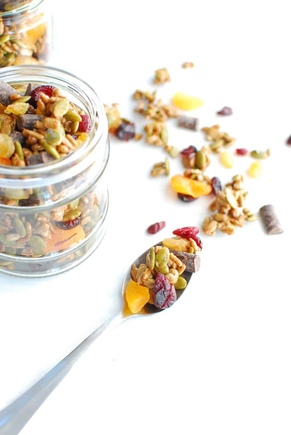 A spoonful of nut free trail mix next to a jar of it