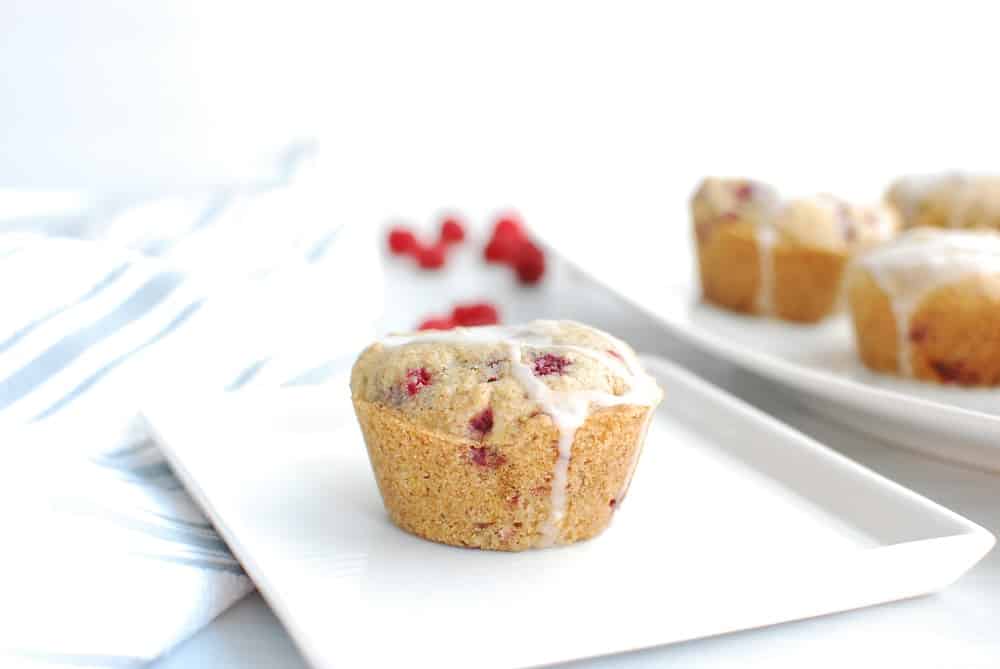 A glazed gluten free vegan raspberry muffin on a plate