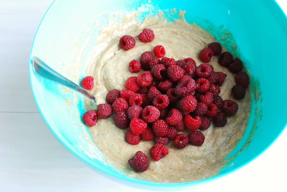 Folding raspberries into vegan gluten free muffin batter