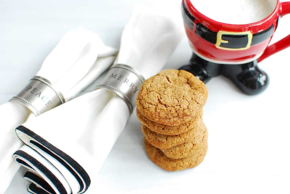 a stack of vegan gluten free gingersnaps next to a mug and napkins