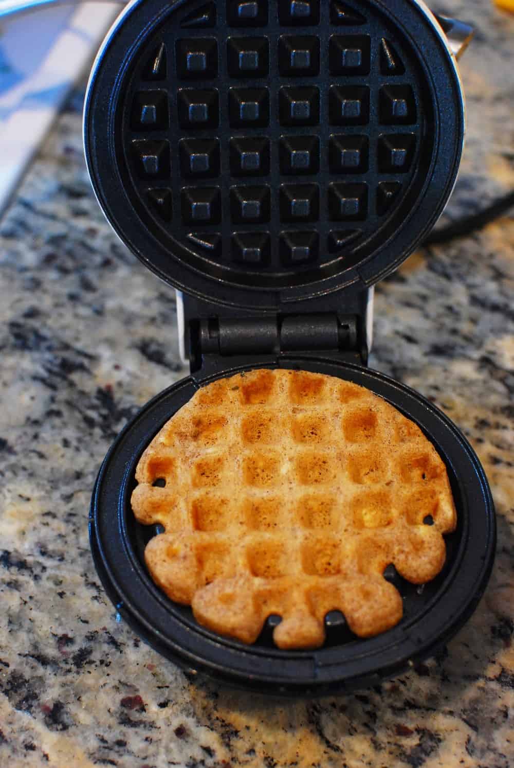 a waffle being cooked in a mini waffle maker