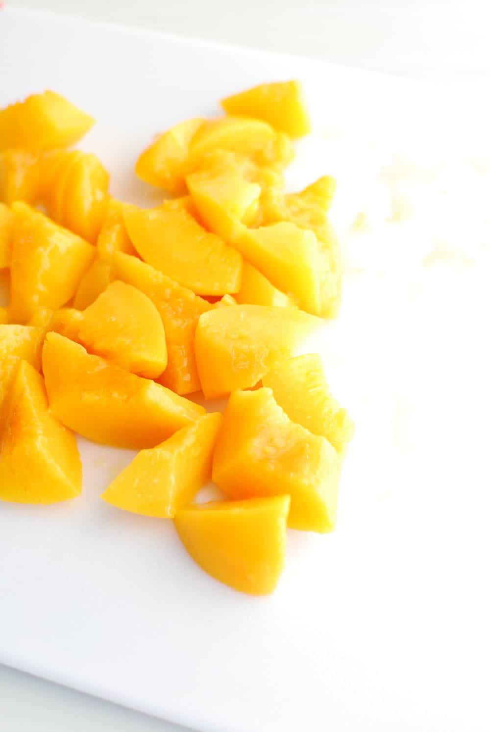 chopped up peaches on a cutting board