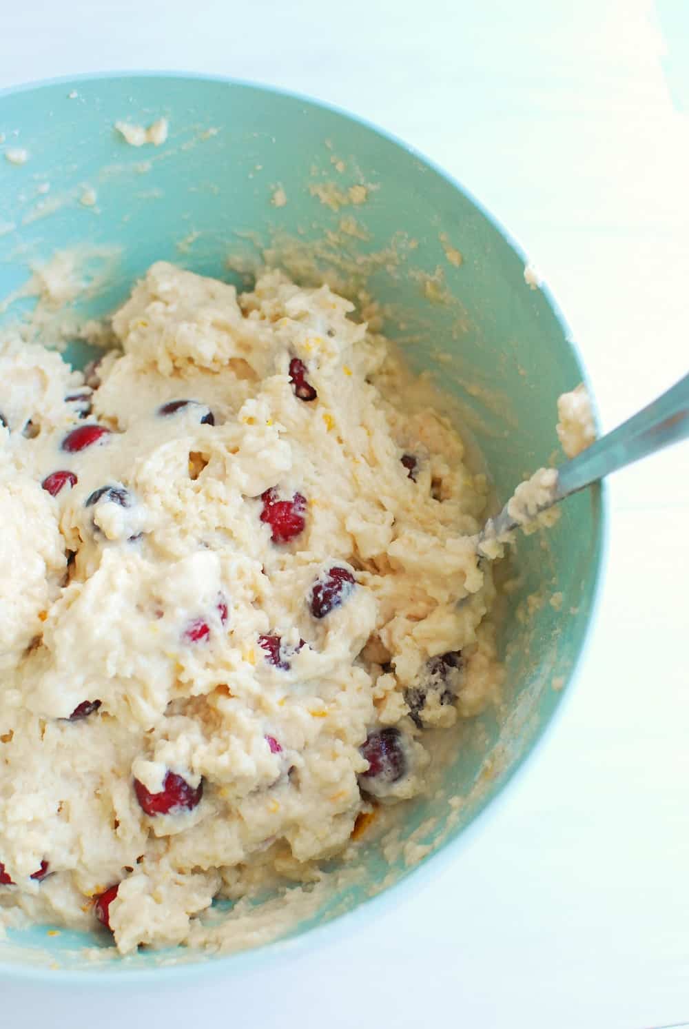 muffin batter in a blue bowl with a spoon