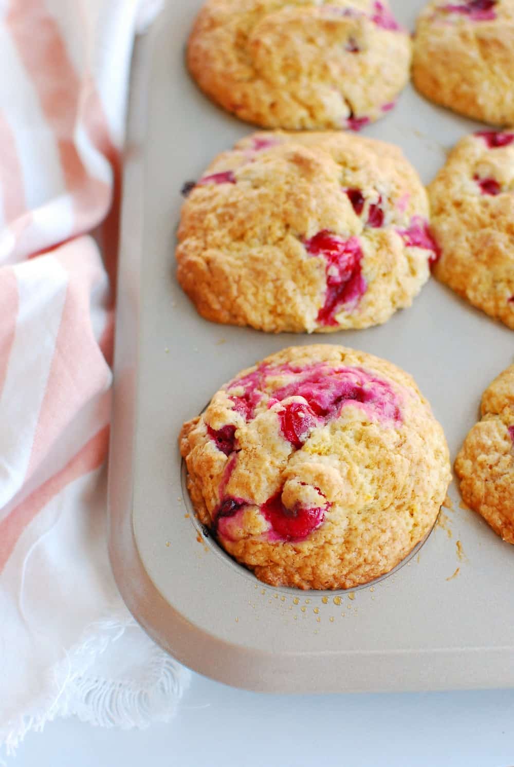 a muffin tin full of cranberry orange muffins