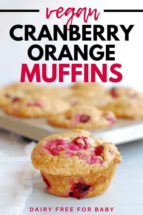 a vegan cranberry orange muffin next to a pan full of muffins