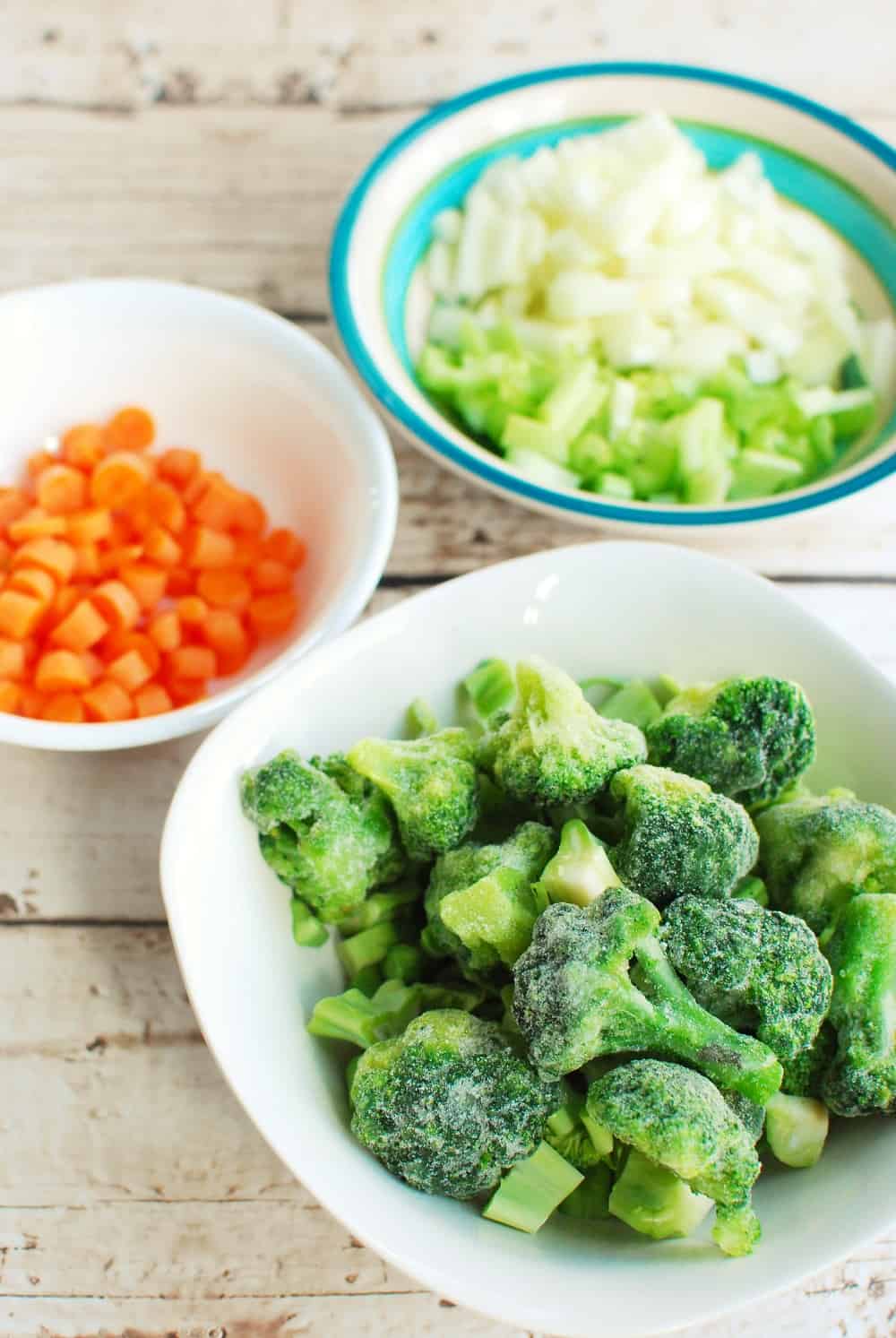 a bowl full of broccoli, a bowl full of carrots, and a bowl full of onions and celery