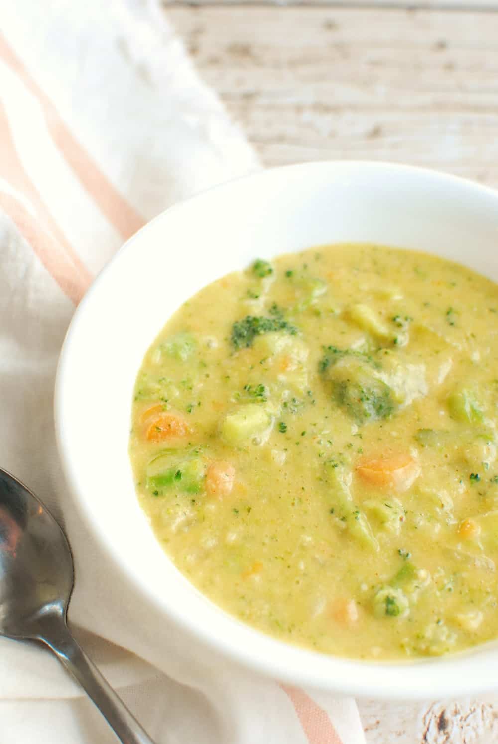 a close up of a bowl of soup with chunks of broccoli and carrots