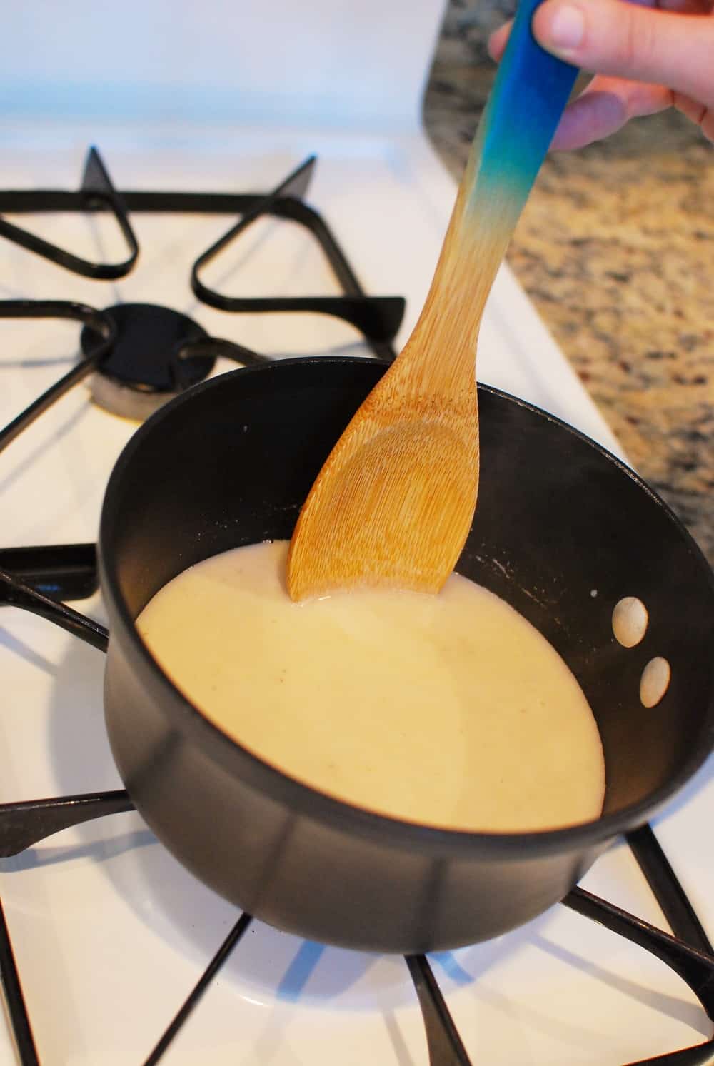 a woman stirring a pot full of dairy free hot chocolate