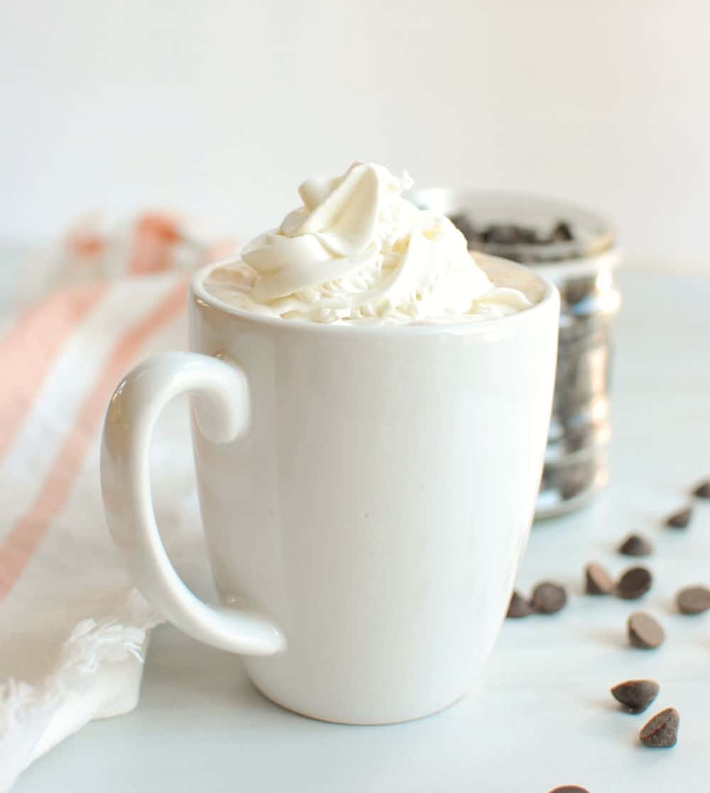 a mug of hot chocolate topped with dairy free whipped cream