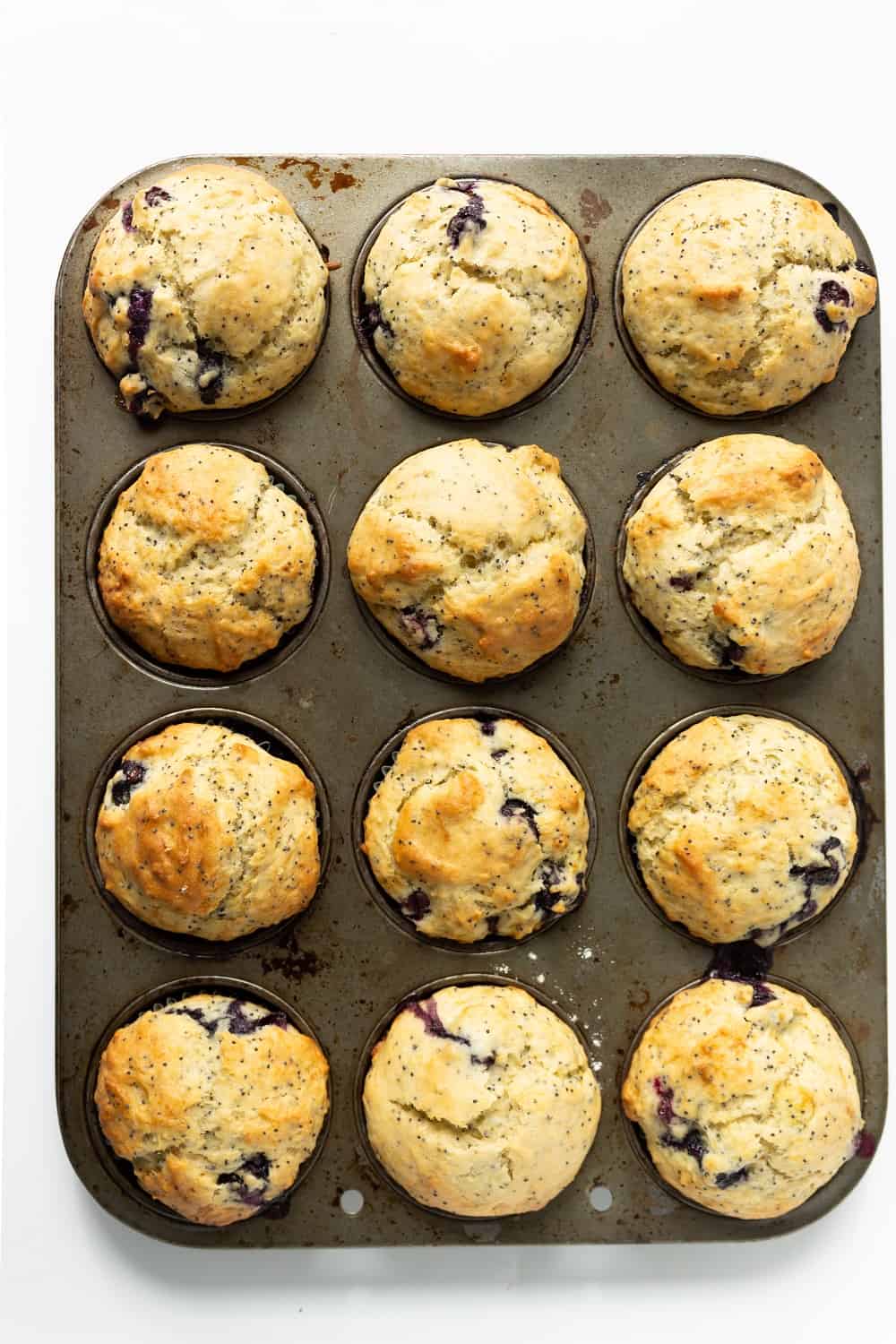 a muffin tin with just-baked dairy free lemon blueberry muffins