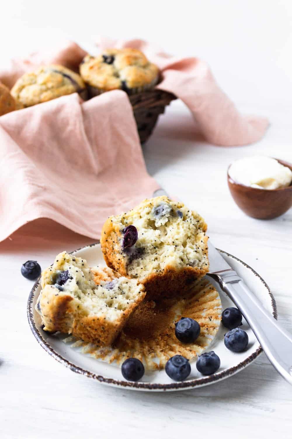 a dairy free blueberry muffin on a plate that's been cut in half