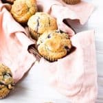 dairy free blueberry lemon muffins in a basket lined with a pink napkin