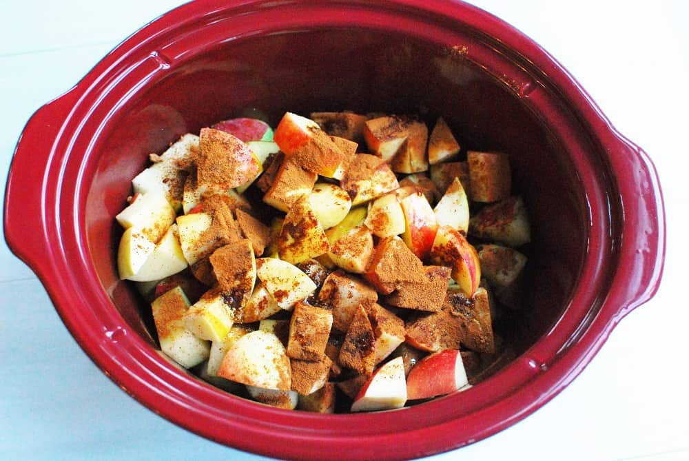 crockpot full of apples, spices, and maple syrup, before cooking