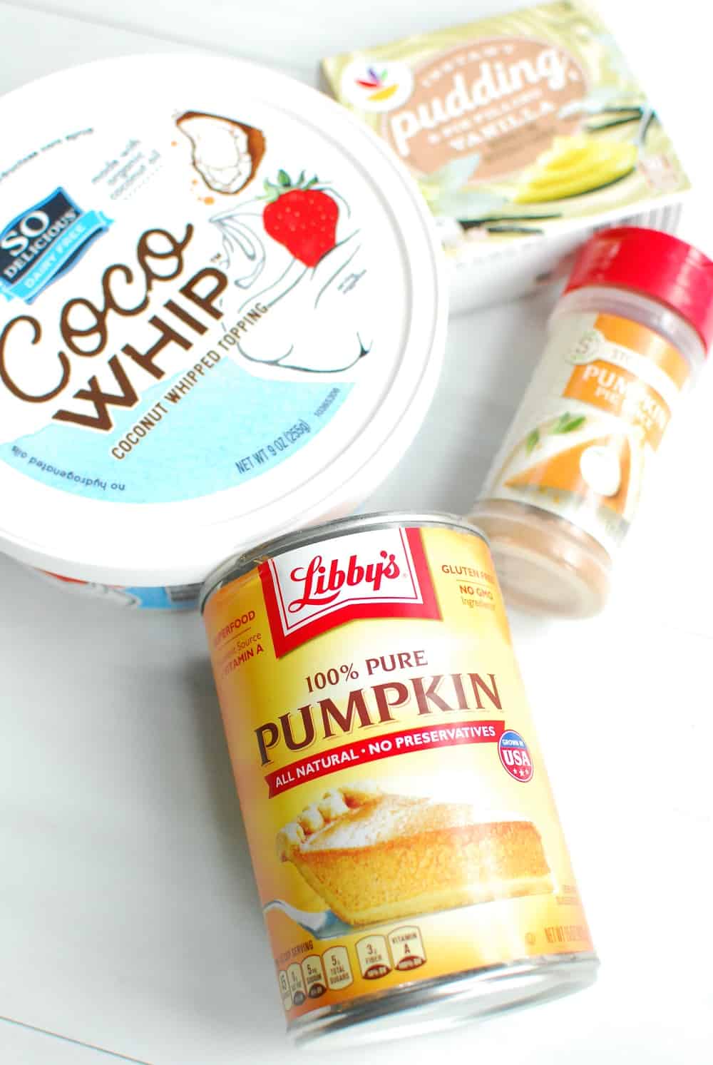 a can of pumpkin, a container of cocowhip, pumpkin spic, and vanilla pudding mx