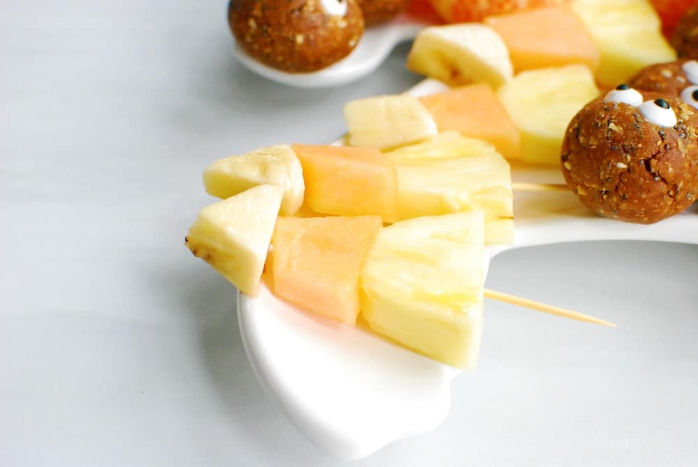 a fruit skewer with pineapple, cantaloupe, and banana