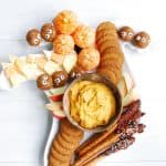 a Halloween charcuterie board filled with five different festive dessert treats, photographed vertically