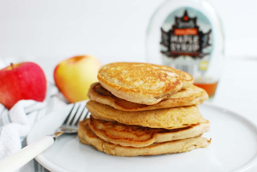 several vegan apple pancakes on a plate with a fork next to them