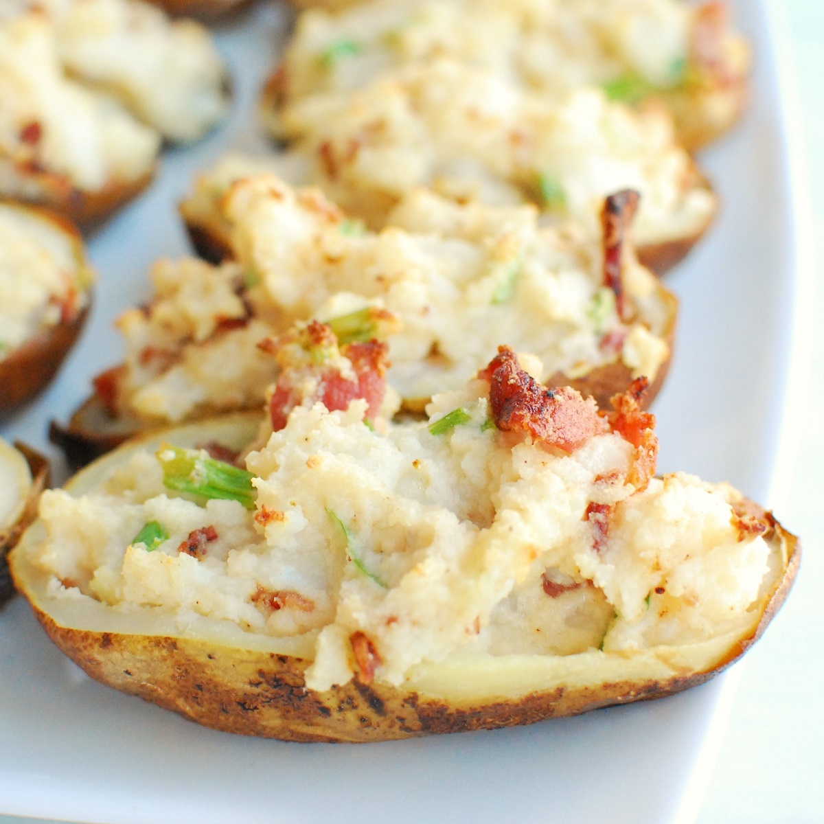 a bunch of dairy free twice baked potatoes on a white serving platter