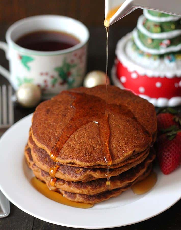 a stack of dairy free gingerbread pancakes with syrup being poured on top