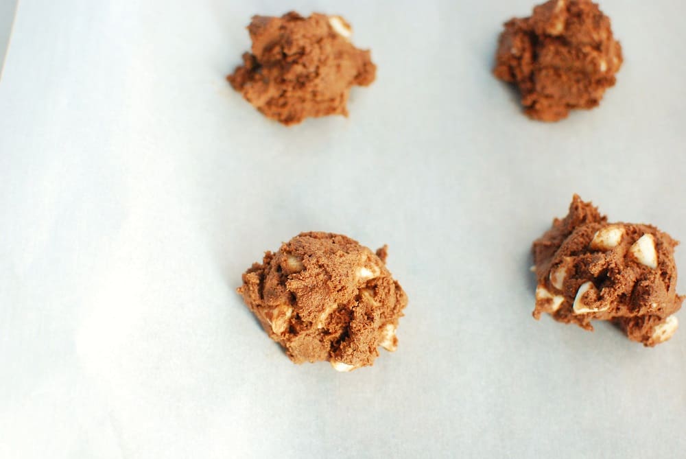 a heaping tablespoon of dairy free chocolate cookie dough on a parchment-lined baking sheet