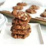 a stack of 5 dairy free chocolate cookies with white chocolate chips on a white plate