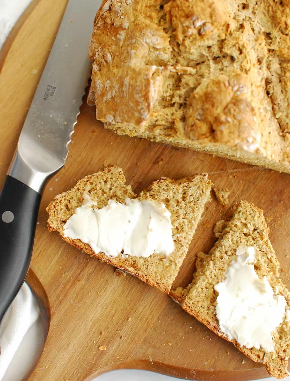 A slice of Irish soda bread with dairy free butter slathered on top.