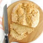 A loaf of vegan Irish soda bread with two slices just cut from the loaf.