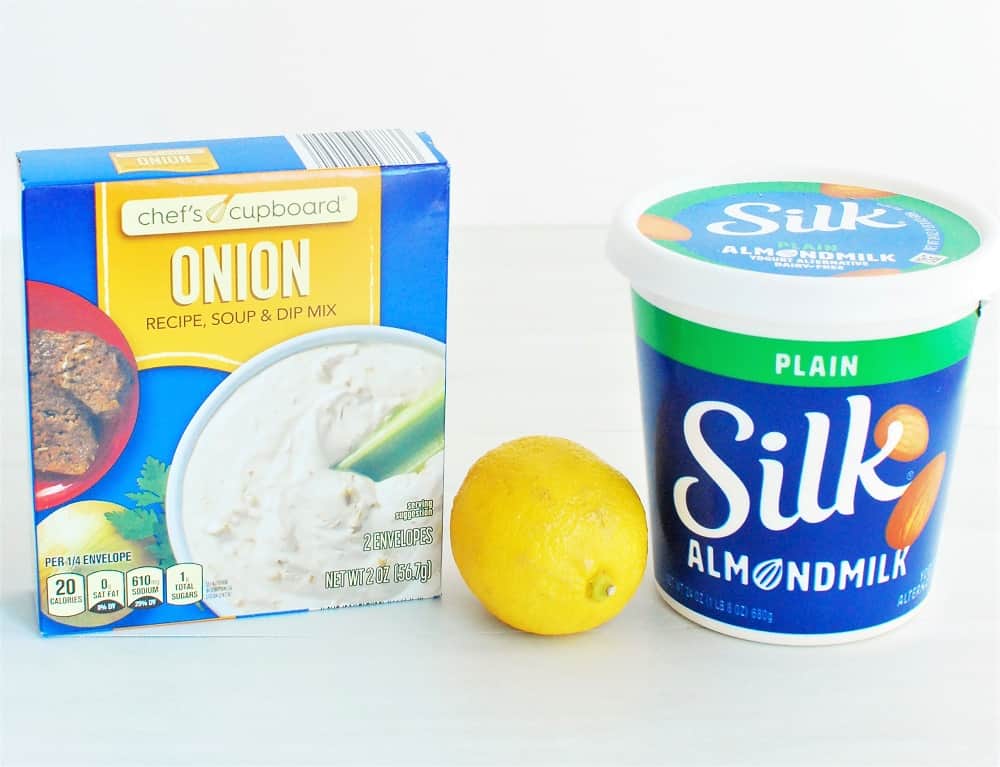 A box of onion dip mix, a lemon, and a container of almond milk yogurt.