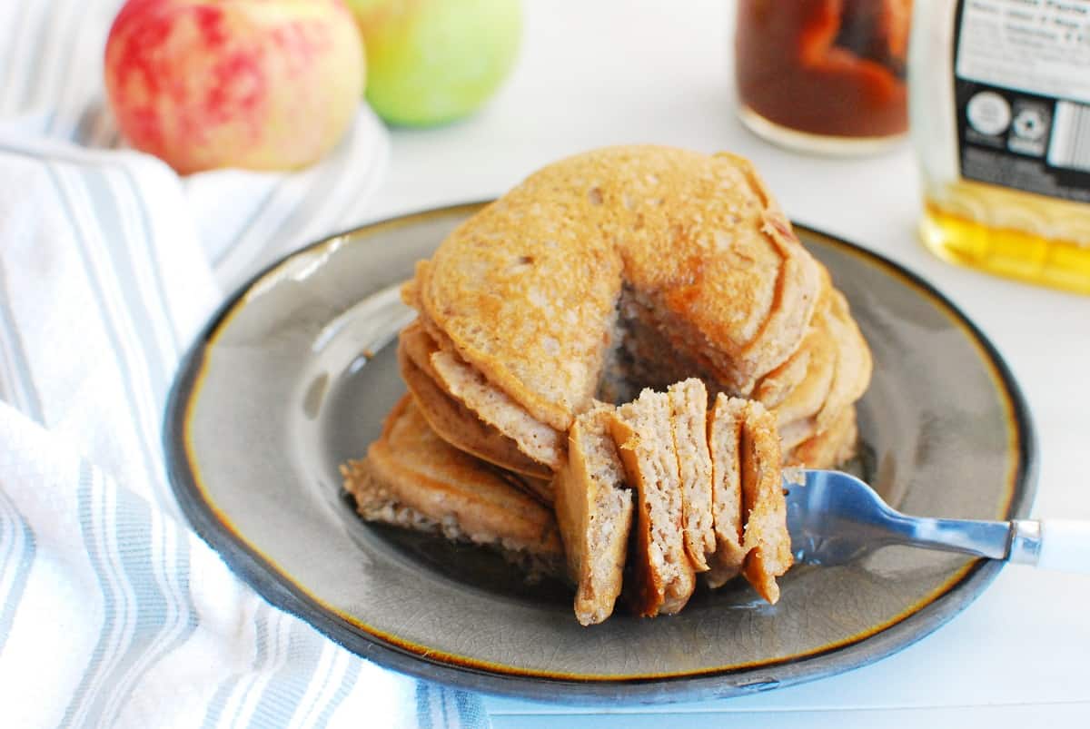 A fork with apple butter pancakes on it laying on a plate.