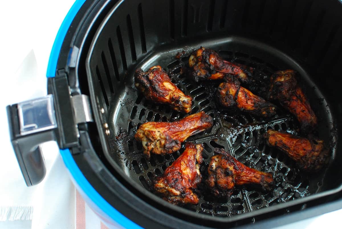 Jerk chicken wings in the air fryer basket.