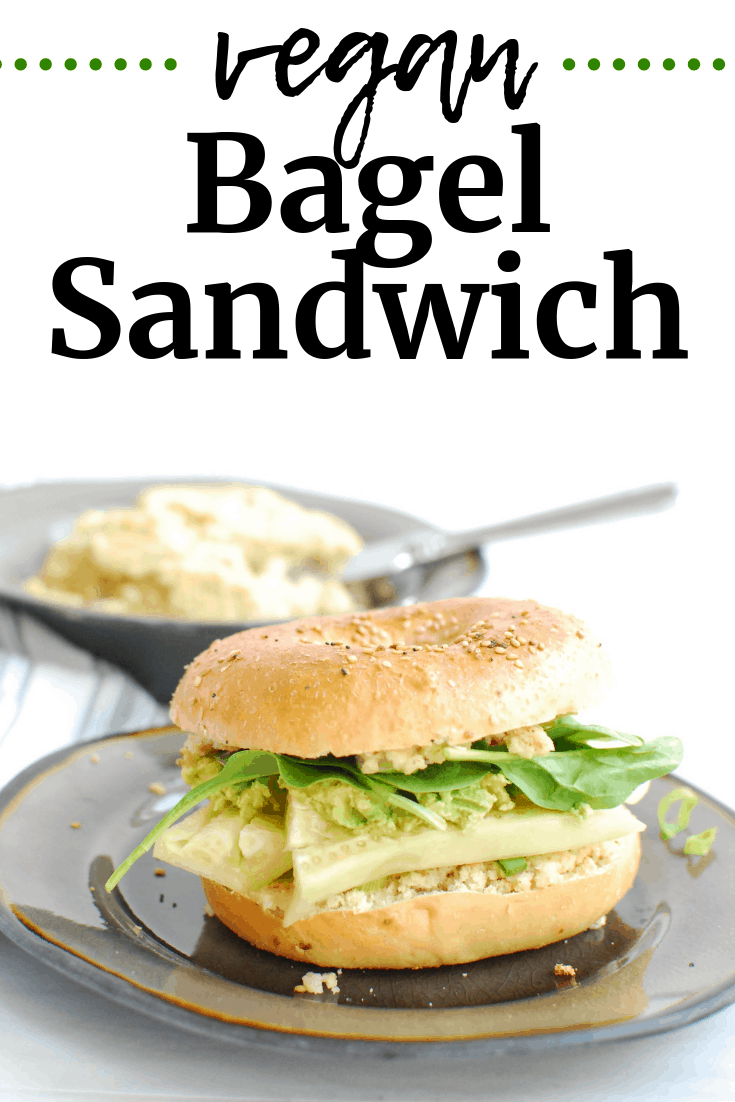 A vegan bagel sandwich on a plate next to a bowl of dairy free homemade cream cheese.