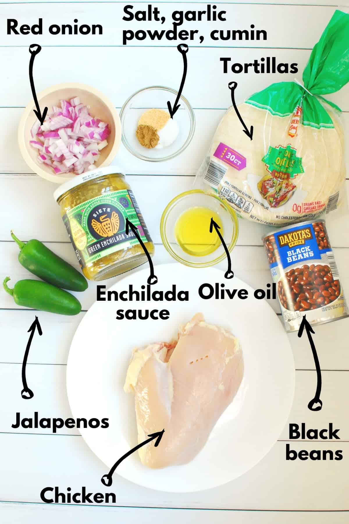 All the ingredients for the dish, including chicken, jalapenos, red onion, enchilada sauce, olive oil, beans, spices, and tortillas.