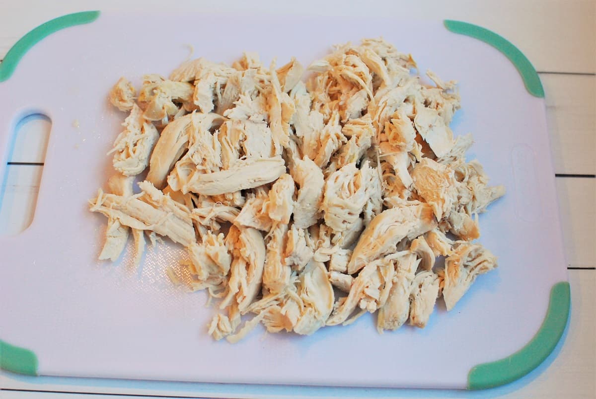 Shredded chicken on a cutting board.