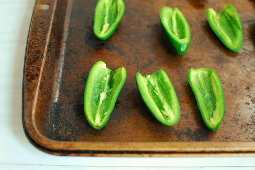 Jalapeno halves on a baking sheet.