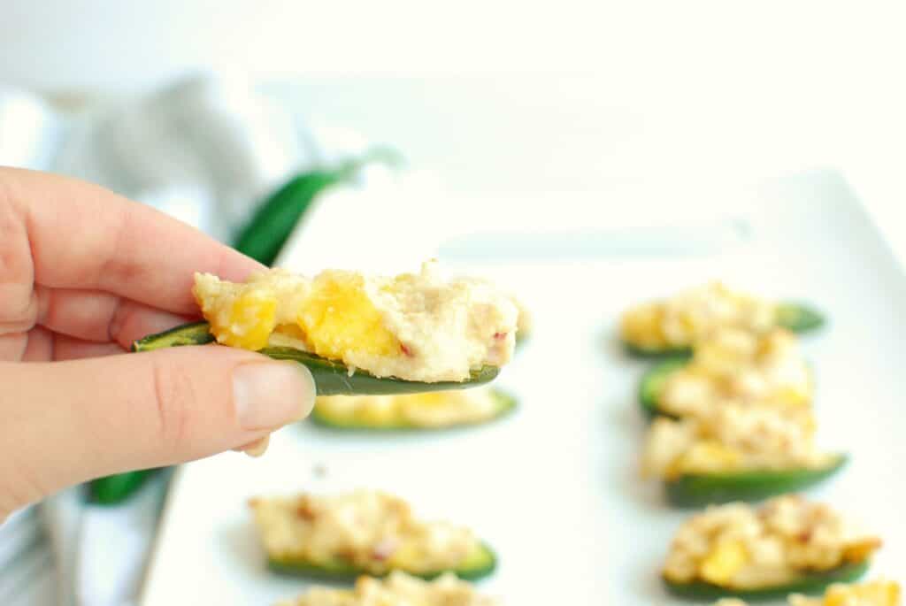 A woman's hand holding a jalapeno popper.