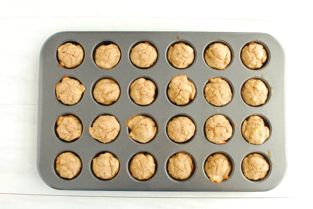 A baked tray of mini baby banana muffins.