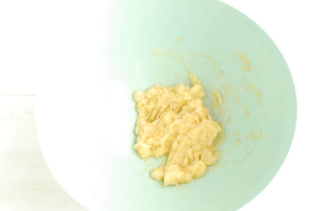 Mashed banana in a mixing bowl.