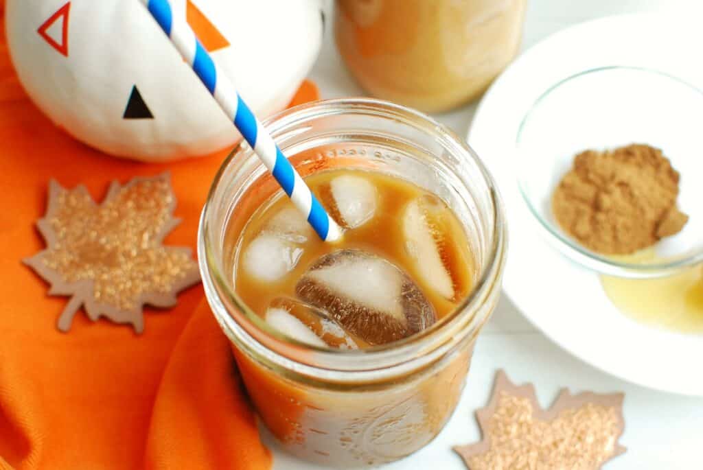 A cup of iced coffee with pumpkin spice creamer added to it.