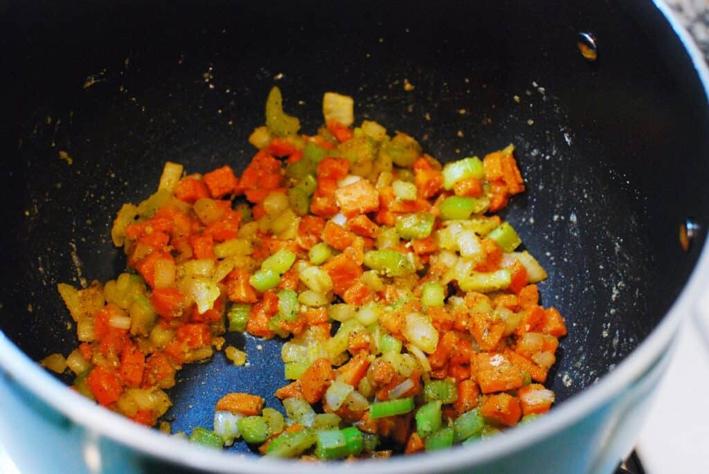 Flour added to vegetables in a pot, absorbing the grease.