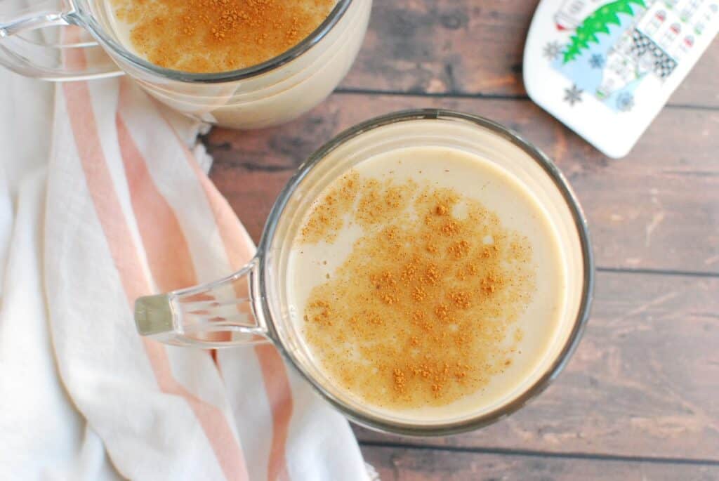 A mug of eggnog with cinnamon sprinkled on top.