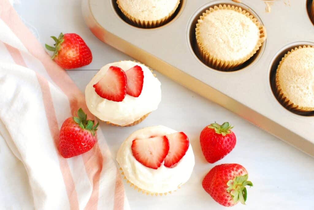 Overhead shot of two angel food cupcakes topped with sliced strawberries.